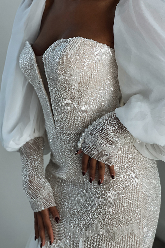 Detail shot of a beaded dress with dramatic balloon sleeves, captured by wedding content creator Ivoura.